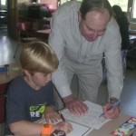 Mr. Baker working with a student at his desk.